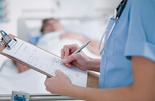 Health care provider monitoring patient after vascular neurosurgery.
