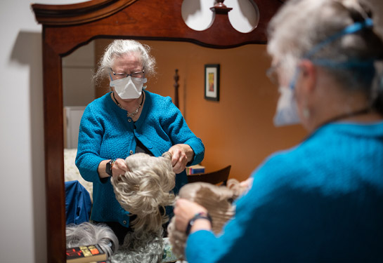 Nursing professor Terri Harvath wears a wig for simulation exercise