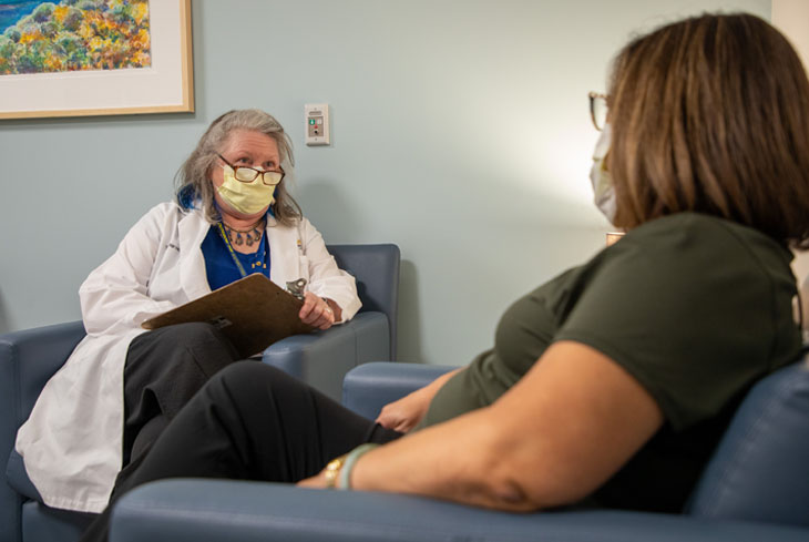 Terri Harvath sits across from a family caregiver in a consultation at the UC Davis Health Healthy Aging Clinic.