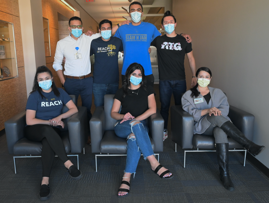 Seven medical students in the REACH pathway pose for picture in face masks inside the UC Davis School of Medicine Education Building