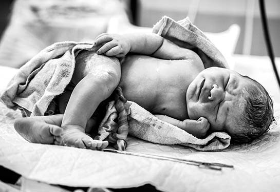 newborn baby with freshly cut cord 