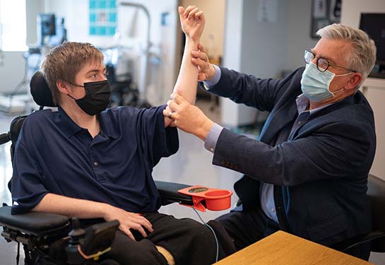 Dr. Craig McDonald examining a kid with Duchenne muscular dystrophy