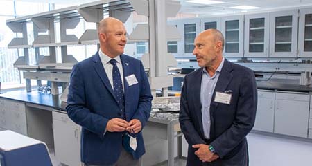 Two men standing and talking inside a laboratory