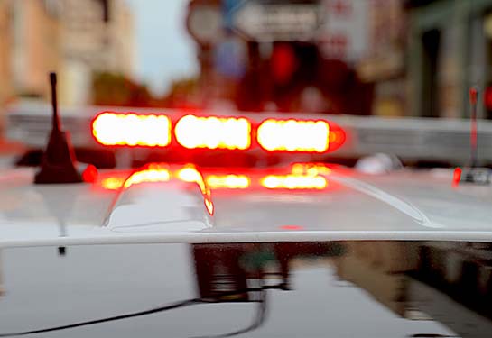 Red and blue lights on the top of a law enforcement vehicle in a city