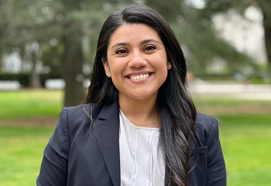 Angelica Martin, wearing white medical lab coat, poses for photo at the California state Capitol building in Sacramento