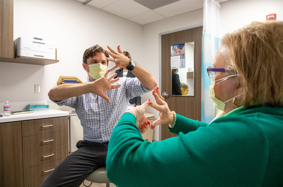  Doctor holds hands with fingers touching while patient mirrors the behavior