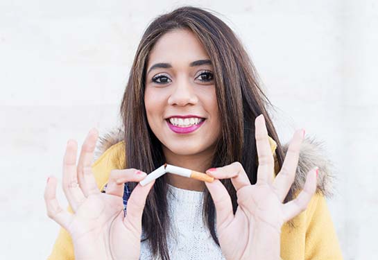 Woman breaking a cigarette in half