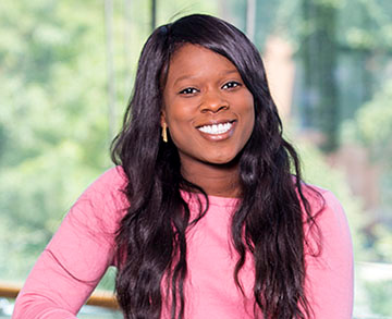 Black woman with long dark hair, pink blouse 