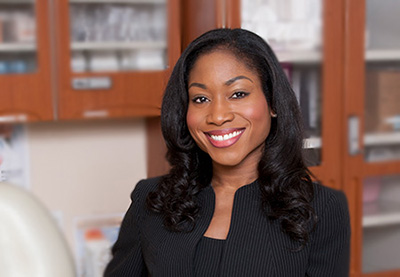 Woman with black hair black pin-striped skirt suit in a medical office.