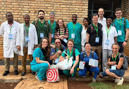 Group of individuals wearing scrubs and white lab coats posing in picture