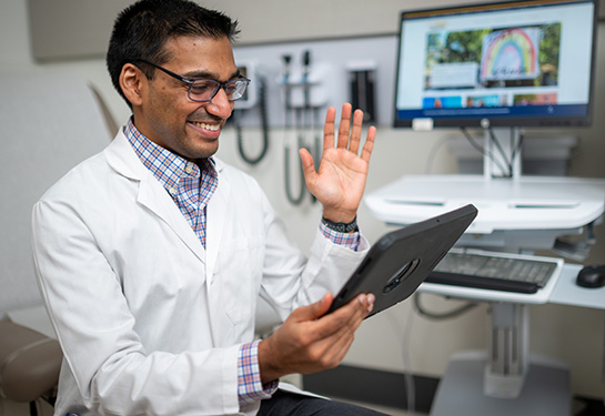 Dr Vinu Ninan wearing a white coat during a virtual health visit