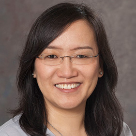 Woman wearing gray sweater and glasses