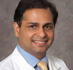 Man wearing white coat and a yellow tie