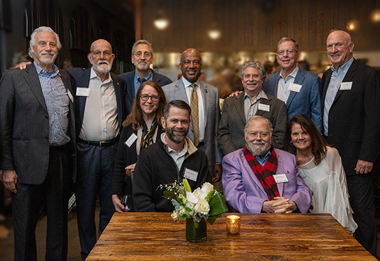 A group of eleven people wearing business clothing and business casual are gathered together for a photograph. 