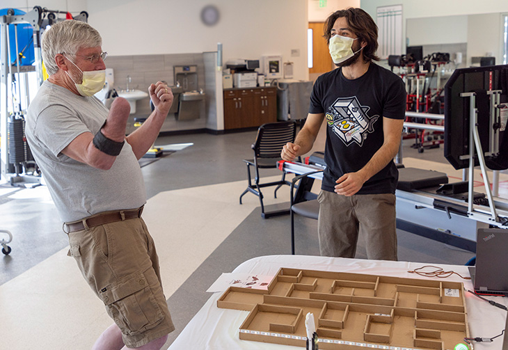 Right arm amputee cheers after completing a task with a bioengineering device on his right limb. 