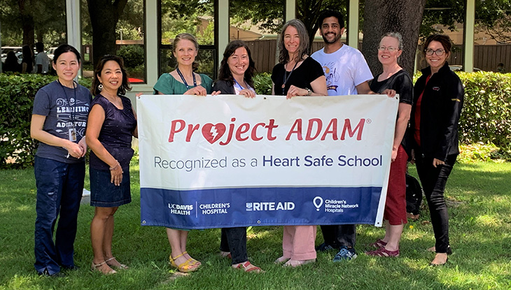 District nurses hold Heart Safe Schools banner