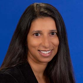 Head and shoulder photo of woman with long brown hair smiling into camera