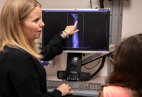 Woman pointing at x-ray of wrist and hand