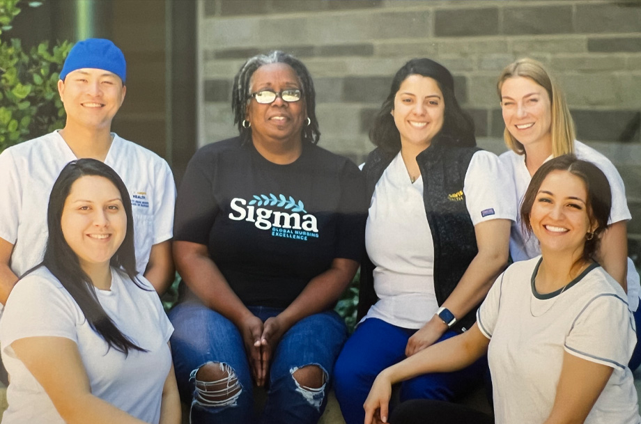 Tonja Copeland, center, with group of nursing students sitting side by side smiling at camera