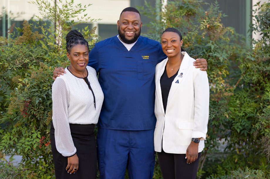 Aron King stands in center with arms around shoulders of Calene Roseman, left, and Dajanae Gresham-Ryder