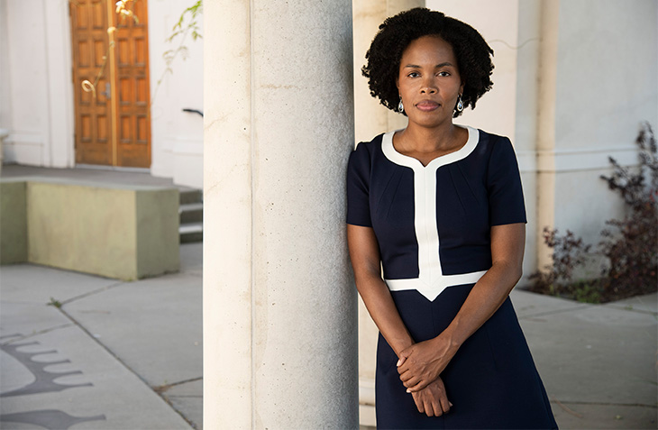 A woman wearing a dark blue dress standing outside