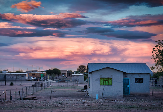 House with a fence and tree under the sky in a rural area