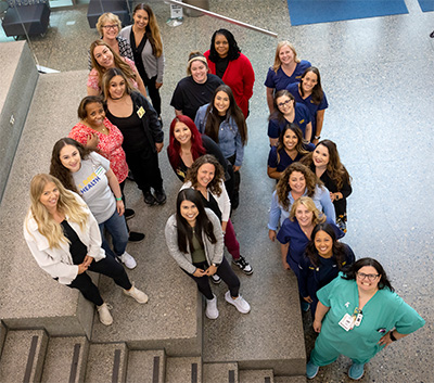 22 volunteer doulas stand on three different steps