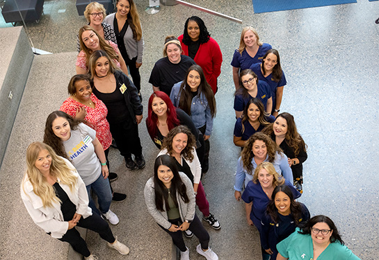 22 volunteer doulas stand on three different steps.