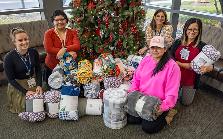 Blankets stacked in front of tree 