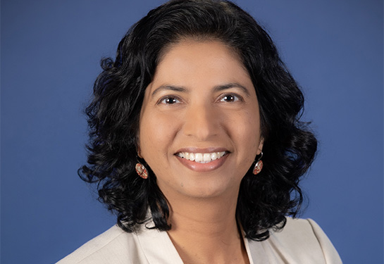 Smiling woman with shoulder length wavy black hair