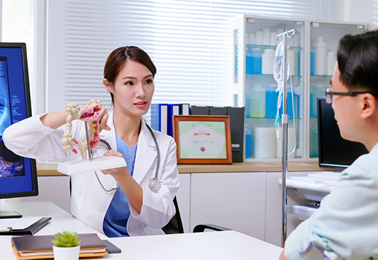 Female doctor showing patient in an office a colorectal image