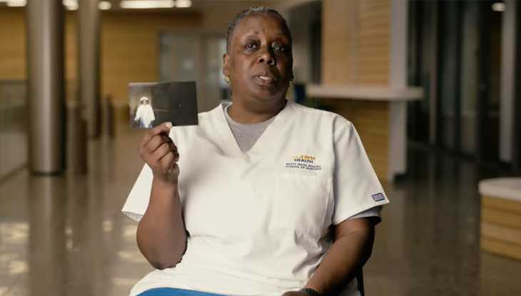 Tonja Copeland seated and holding photo of herself as a young girl