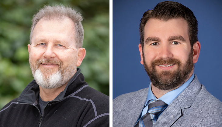 Professor Andreas Bäumler is wearing black sweater and Derek Bays is wearing a grey suit and tie. They are both smiling and looking at the camera.