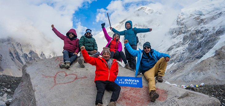 Un grupo de seis hombres y mujeres celebran con manos al aire al llegar al Un grupo de seis hombres y mujeres celebran con manos al aire al llegar al campamento base del Monte Everest base del Monte Everest