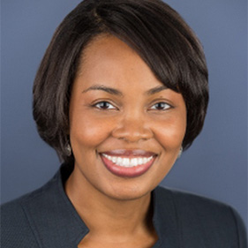 Headshot of a smiling woman against a blue background. 