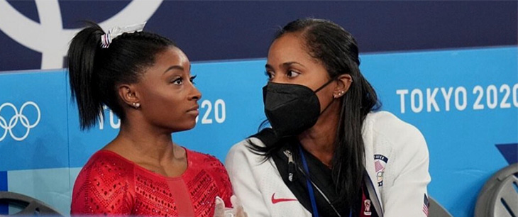 Dr. Marcy Faustin sitting next to US Gymnast Simon Biles during the Tokyo Olympics