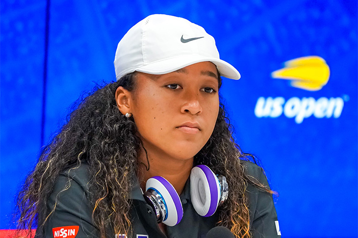 Naomi Osaki being interviewed with headphones around her neck.