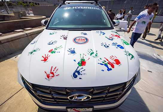 Hood of white Hyundai with colorful handprints