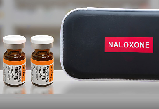 Two brown vials of naloxone and black case that says Naloxone