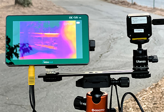 A small camera screen shows thermal readings of green, yellow and blue near a bike path. 