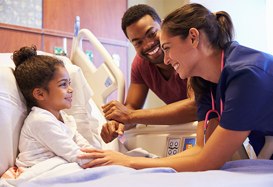 Child in a hospital bed with dad and medical person 