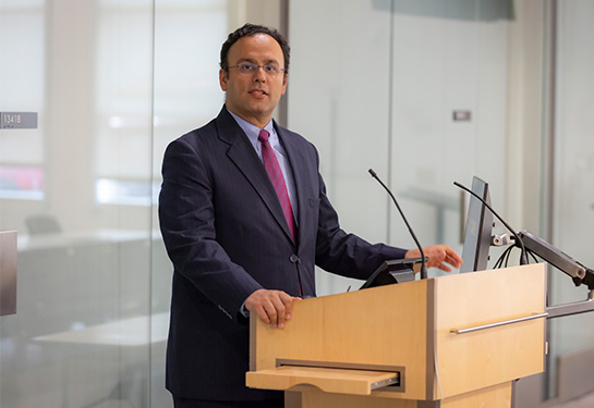 Man standing at a podium speaking.