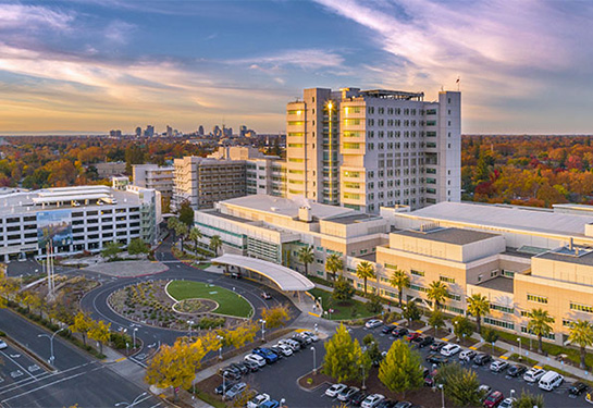 Aerial view of UC Davis Medical Center during the day with the skyline of Sacramento in the distance.