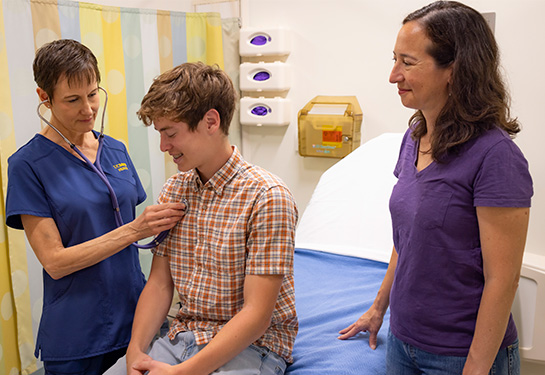 Mom and son in a patient room with a medical provider