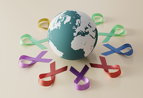 World globe surrounded by multi-colored cancer ribbons