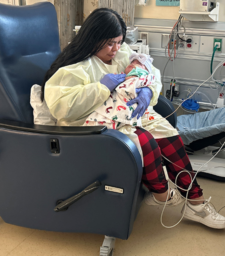 Woman holds baby in the NICU