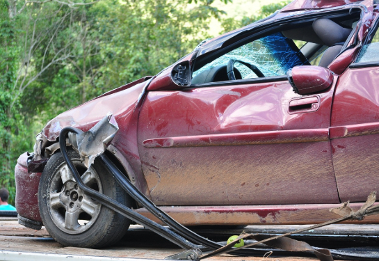 Side view of a damaged red car after a car accident