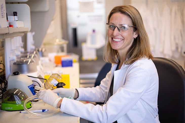 Dr. Erin Brown in her white lab coat smiling to the camera