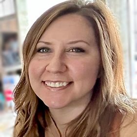 A woman with long hair in a peach shirt.