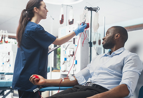 Nurse checking on a donor giving blood.